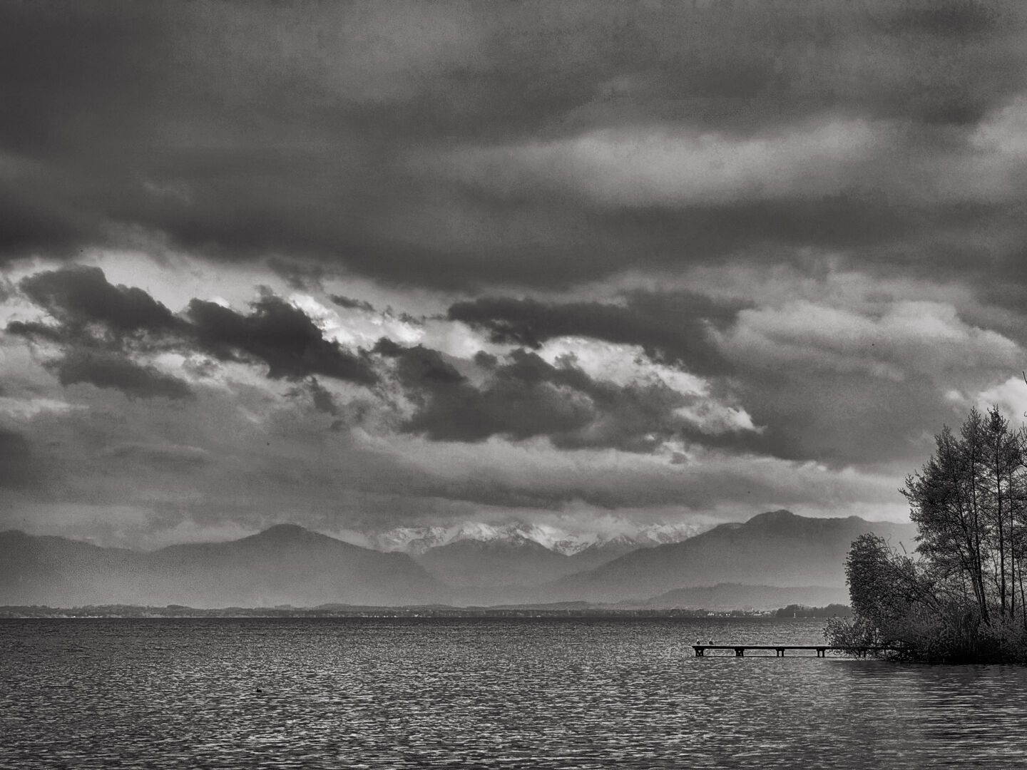 I'm at Lake Starnberg and the weather is so bad that a black and white photo shows the situation better than a color photo. The onset of winter swallowed up all the colors. Shortly afterwards, the first snowflakes fell.

#winterinapril #stormyweather #bayern #blackandwhitephotography #landscapephotography #photography