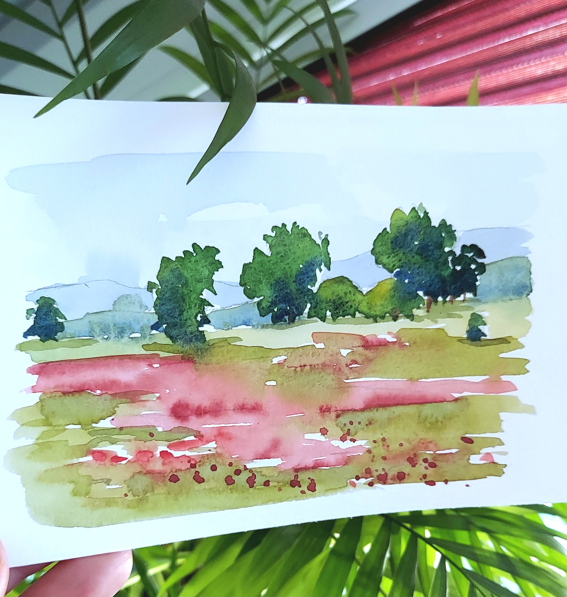 Aquarell eines Mohnfelds mit Bäumen.