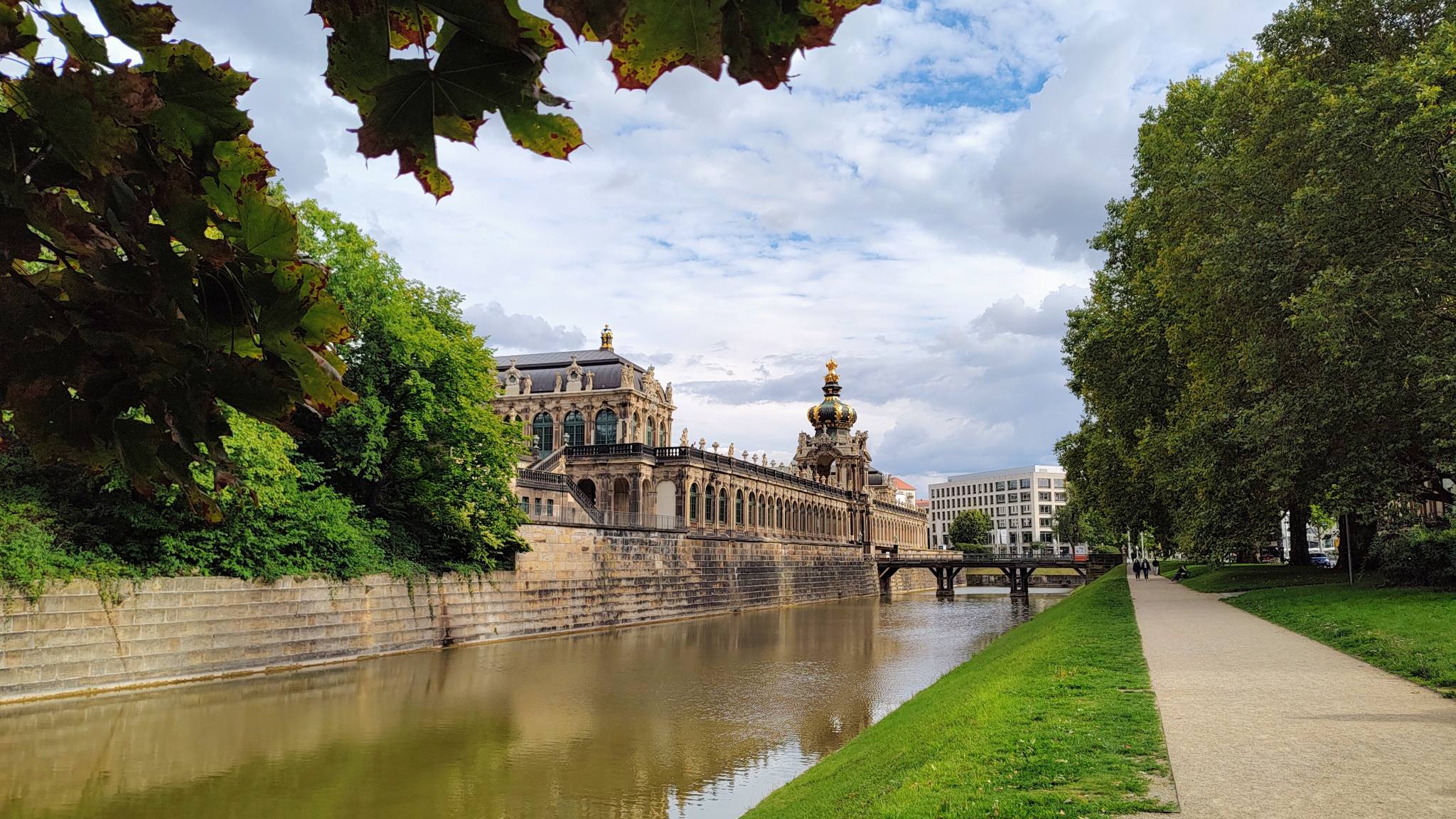 Dresden Zwinger seen from the Ostra-Allee, with its moat in the foreground and the Wallgrabenbrücke (moat bridge) and the Kronentor (crown gate) in the distance