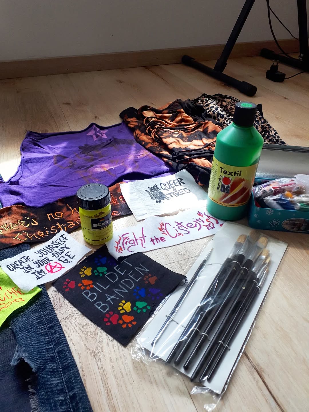 bunte Shirts und Ptches, Textilfarbe, Pinsel.