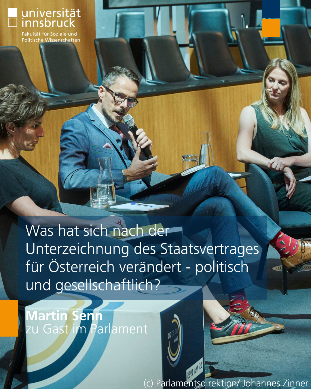 Foto von Martin Senn im österreichischen Parlament mit Mikrofon in der Hand während er eine Frage beantwortet, links von ihm sitzt Lucile Dreidemy und rechts die Moderatorin der Diskussionsrunde  Bianca Ambros. Auf dem Foto steht der Text "Was hat sich nach der Unterzeichnung des Staatsvertrages für Österreich verändert - politisch und gesellschaftlich? Martin Senn zu Gast im Parlament"