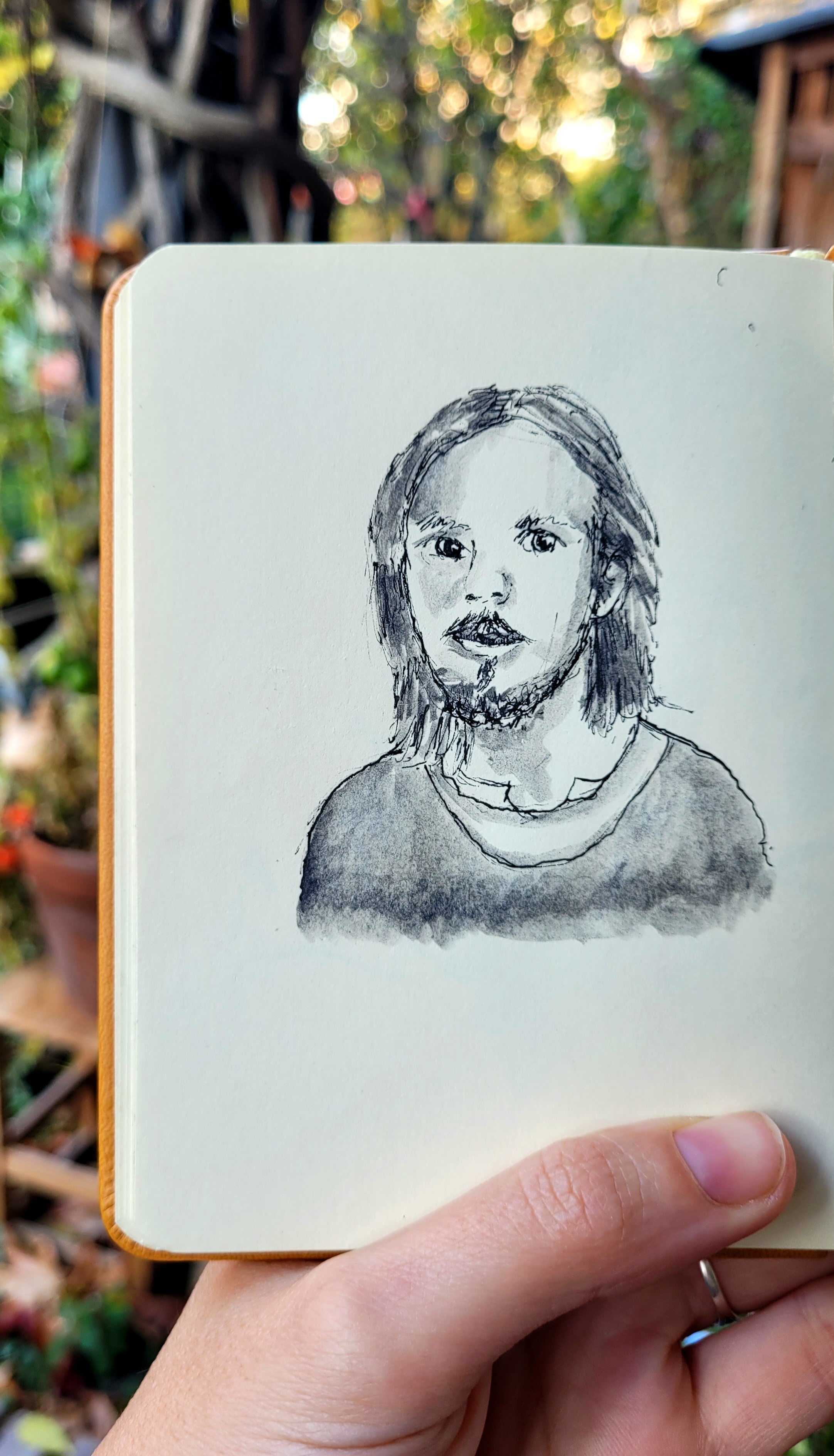 Das Bild zeigt einen jungen Mann. Nur Kopf und ein Teil des Oberkörpers sind zu sehen. Das Bild wurde mit Fineliner und Aquarell-Graphit erstellt.