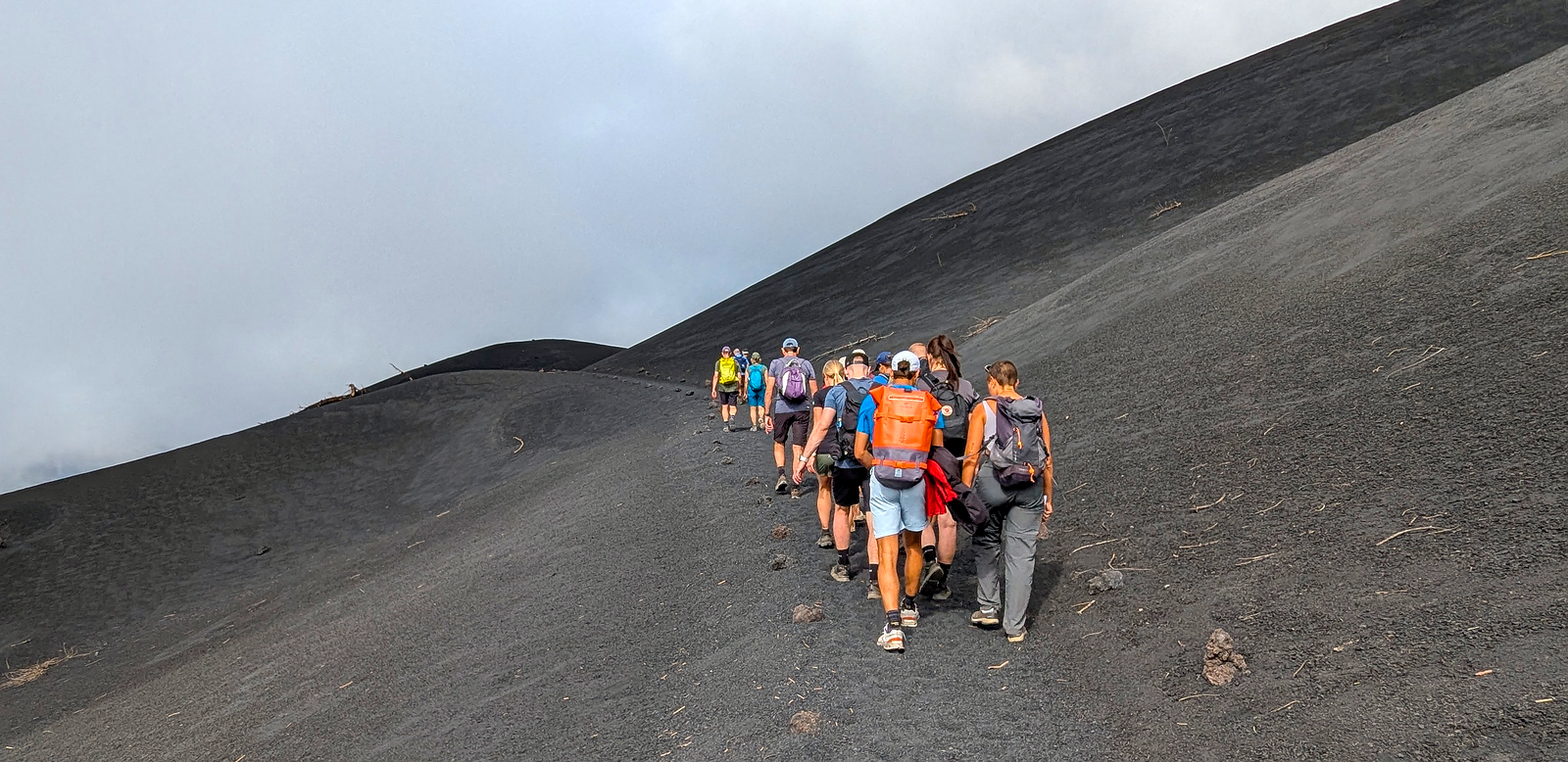 Wanderung am Vulkan entlang über schwarze Lavaasche.