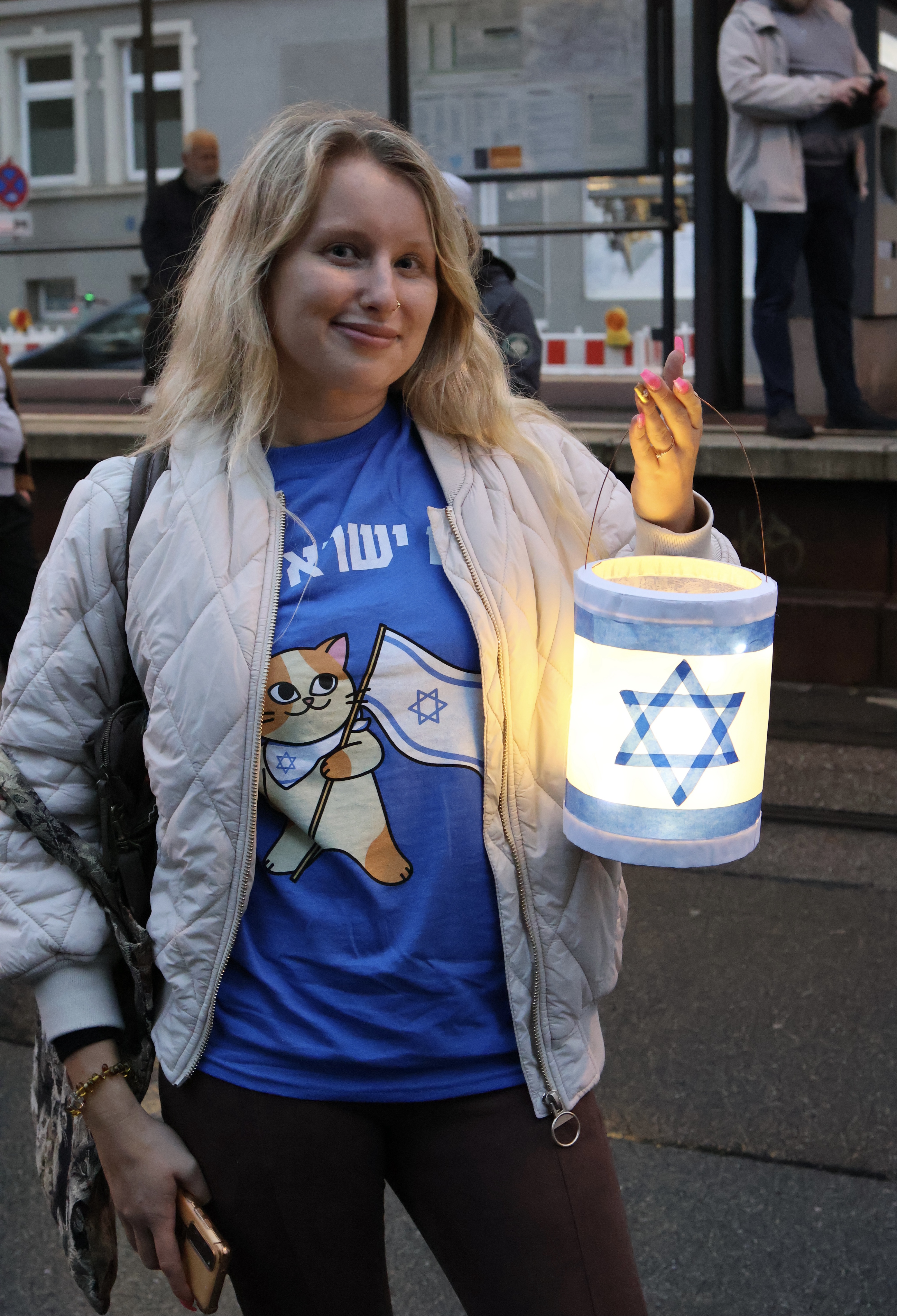 Ganze Person mit blonden, langen Haaren (Oberkörper, Hochformat).
